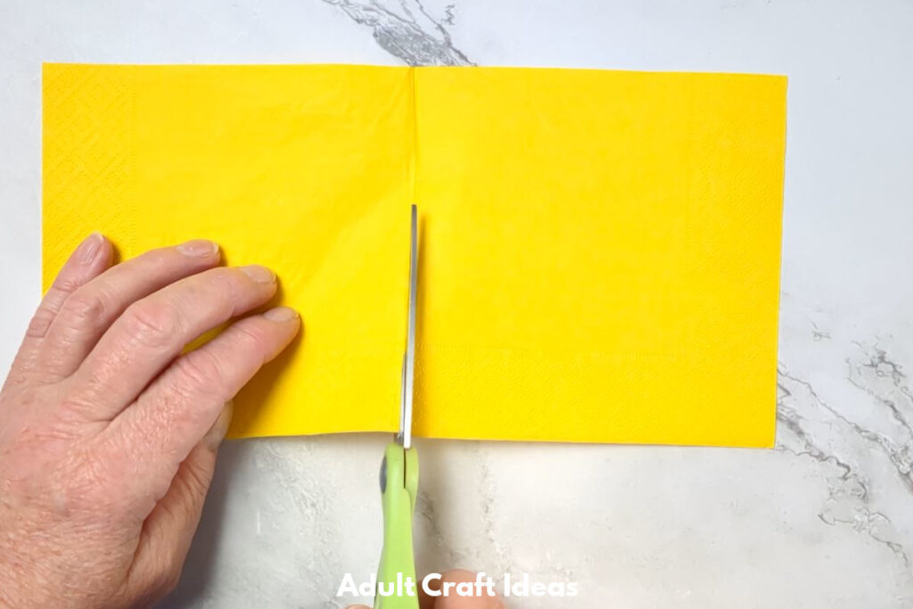 Yellow paper being cut in half.