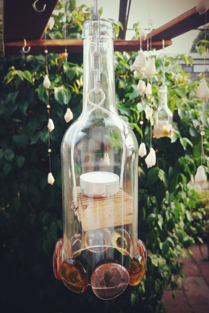 Upcycled wine bottle turned into garden candle lighting.