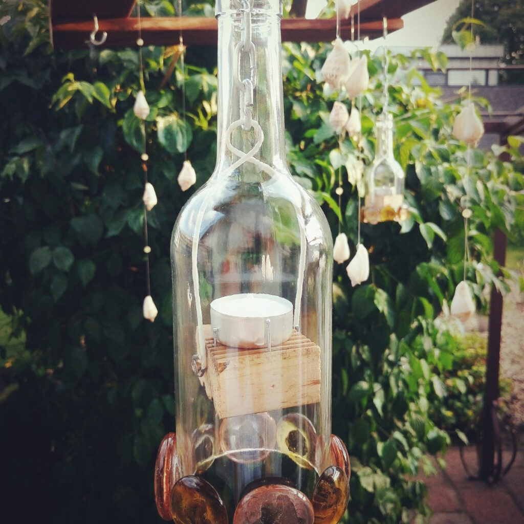 Upcycled glass bottle holding a tea light candle.